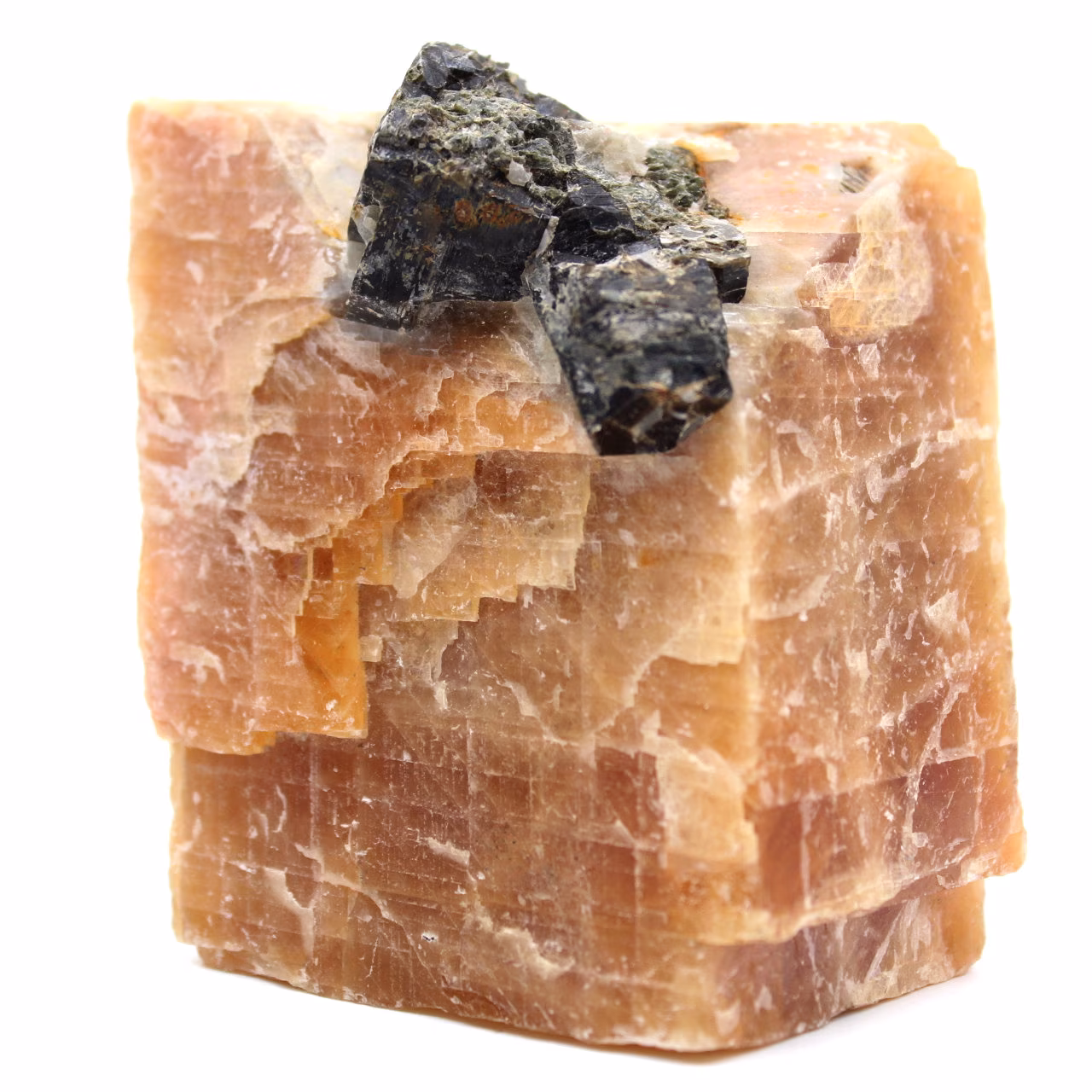 Schwarze Glimmerkristalle auf orangefarbenem Calcitblock